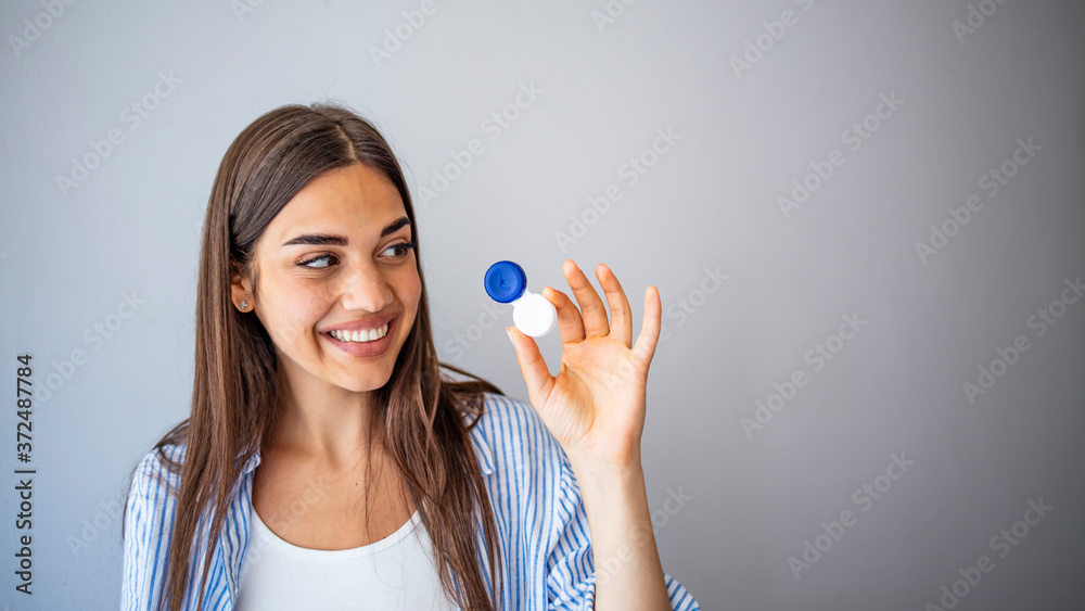 Happy Woman Holding Contact Lenses Case. Woman with Contact Lenses Case in Optical Store - Beautiful girl holding contact lens container in optician shop Happy Woman Holding Contact Lenses Case. Woman with Contact Lenses Case in Optical Store - Beautiful girl holding contact lens container in optician shop