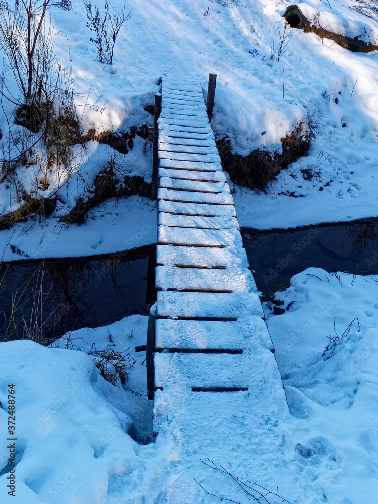 bridge over a small stream in winter in the forest, Moscow bridge over a small stream in winter in the forest, Moscow