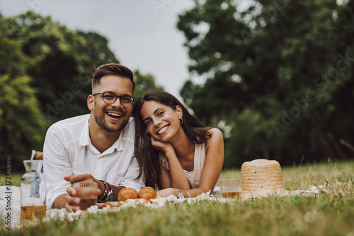 happy young couple sitting on the grass