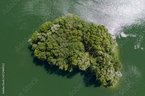 View from above of a wooded small island in a quarry pond in the Hessian Ried / Germany