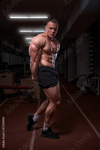 Strong athletic man, bodybuilder. Naked torso, muscular body. Strong chest and shoulder muscles in the gym. Bodybuilding concept © Артур Парфененко