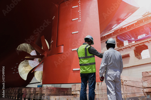 workers at dry dock in shipyard during Underside of ship