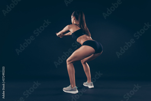 Full size rear photo short sport suit lady practicing body weight workout sit ups improve butt muscle isolated black background
