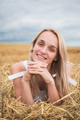 Portrait of bohemian girl with white art posing over wheat field a summer day