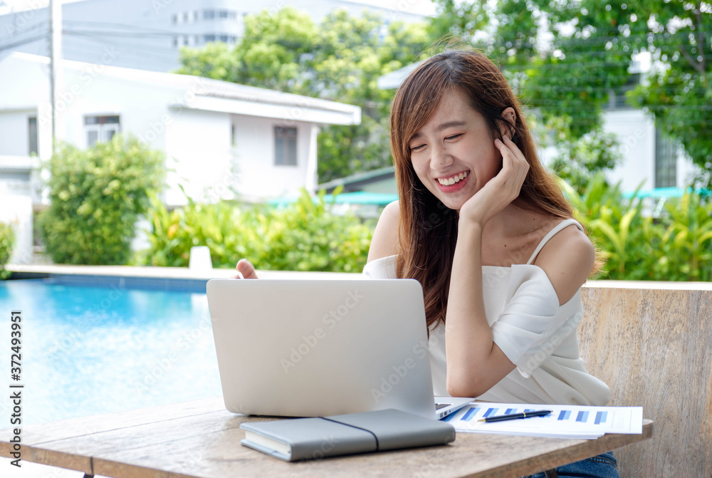 portrait young Asian woman relaxing using laptop computer checking social apps and working.Communication and technology concept. portrait young Asian woman relaxing using laptop computer checking social apps and working.Communication and technology concept.