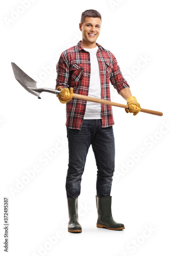Male gardener in boots holding a shovel
