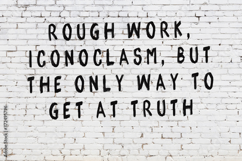 Foto White brick wall with painted black inscription of wise quote