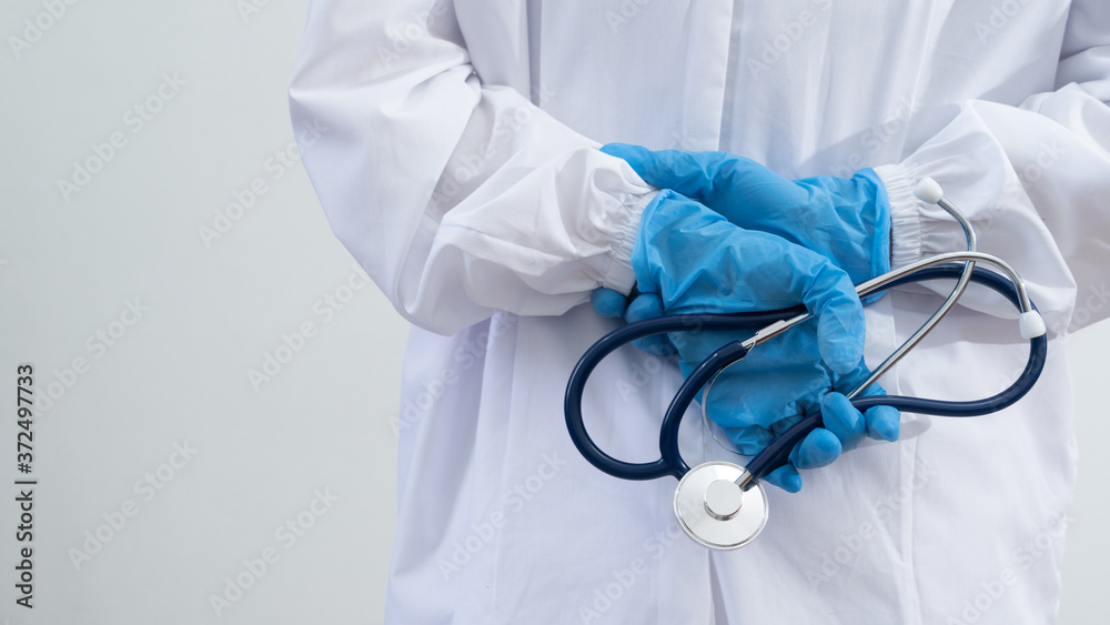Doctor wear uniforms and gloves holding stethoscope to prepare for work during the spread of the coronavirus.Medical and Health care concept Doctor wear uniforms and gloves holding stethoscope to prepare for work during the spread of the coronavirus.Medical and Health care concept