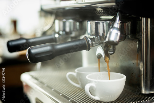 Coffee machine espressos shot and smoke in white cups . photo