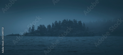 Silhouette of a forested island lost in the fog