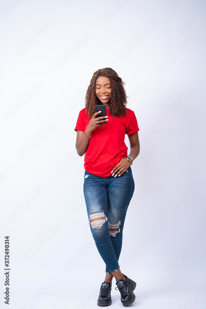 young pretty black lady using her phone and smiling young pretty black lady using her phone and smiling