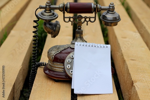Wallpaper Mural 
Notepad and vintage telephone, on wooden beams. Torontodigital.ca