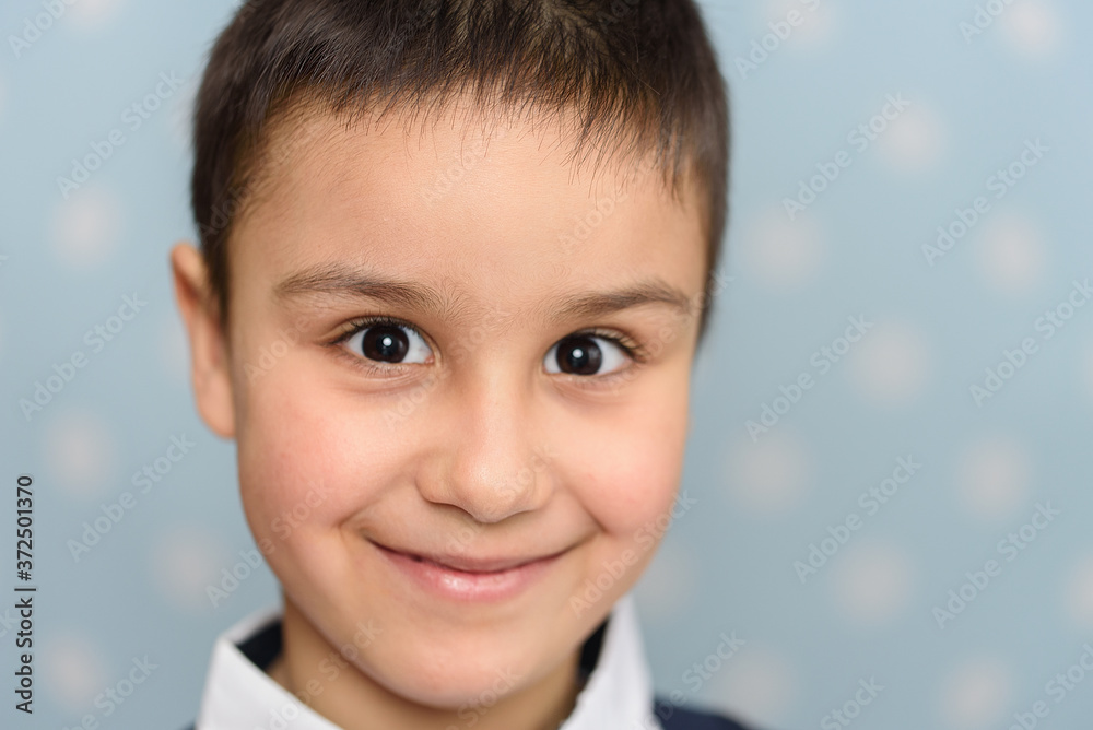 Head And Shoulders Portrait Of Handsome Young Boy. Happy 6 year old European boy posing over blue studio background. Head And Shoulders Portrait Of Handsome Young Boy. Happy 6 year old European boy posing over blue studio background.