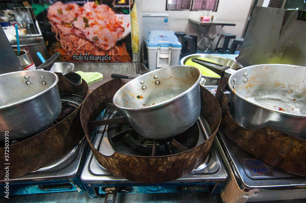 The dirty pots at street food Tomyum ramen noodle truck at Talat Phlu outdoor market in Bangkok Thailand The dirty pots at street food Tomyum ramen noodle truck at Talat Phlu outdoor market in Bangkok Thailand