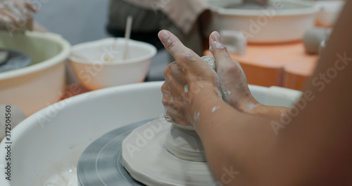 Hand work on pottery wheel, shaping a clay pot