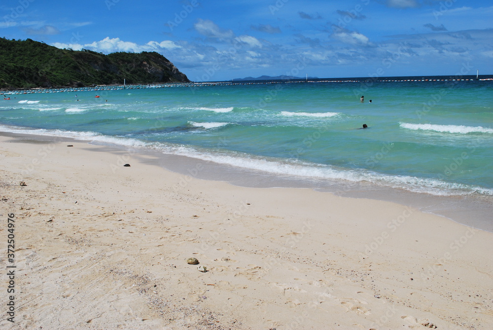 A beach with little waves in the blue sea.