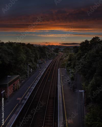 Sunset on Liskeard rail station tracks Cornwall, blue and orange sky
