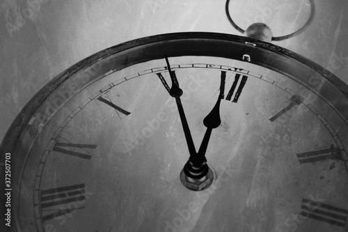 Retro black and white clock with five minutes before twelve