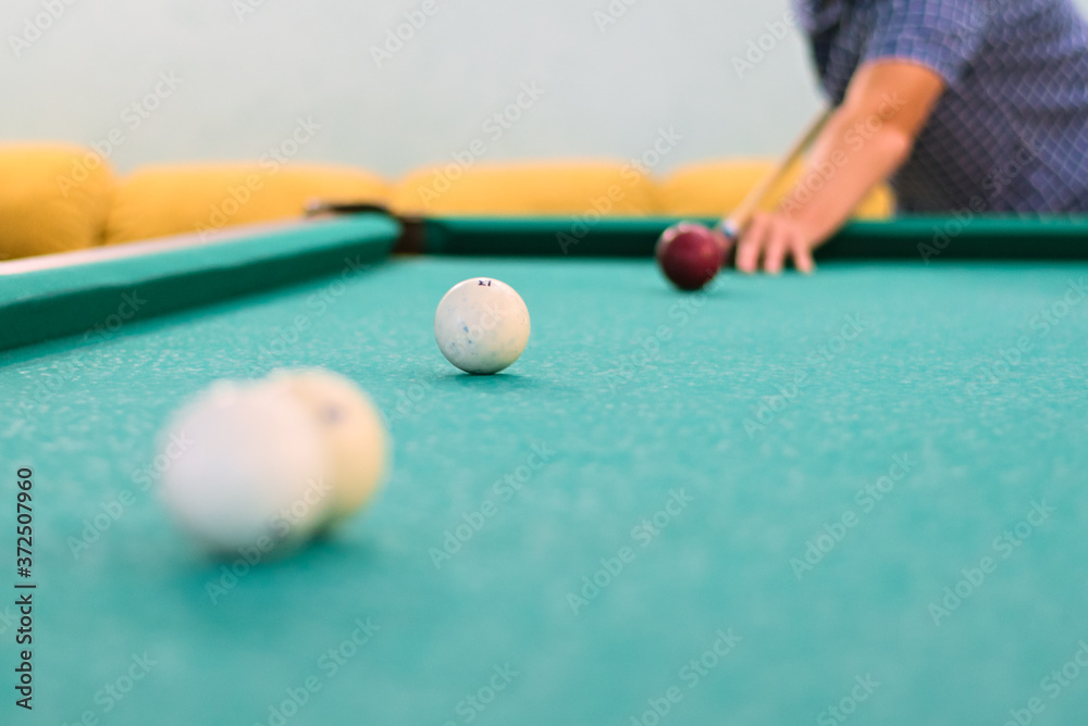 Man's hand and arm playing pool preparing to shoot the white ball of a
