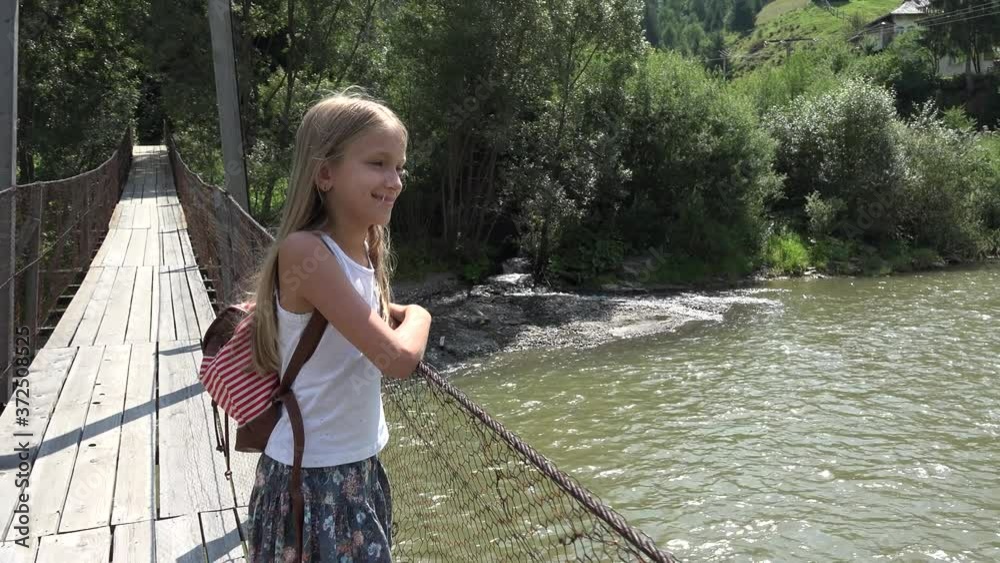 Kid on Bridge at Camping in Mountains Trails, Child Hiking in Excursion, Young Blonde Girl Looking a River, Stream in Nature