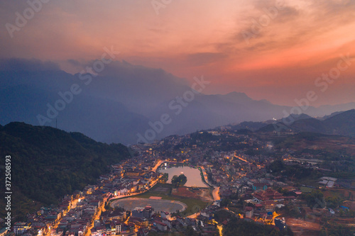 Aerial view of panorama landscape at the hill town in Sapa city, Vietnam with the sunny light and sunset, mountain view in the clouds © CravenA