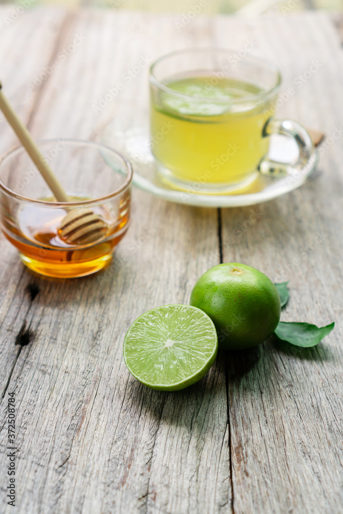 Honey lime drink on wood table with fresh lime and honey. Honey lime drink on wood table with fresh lime and honey.