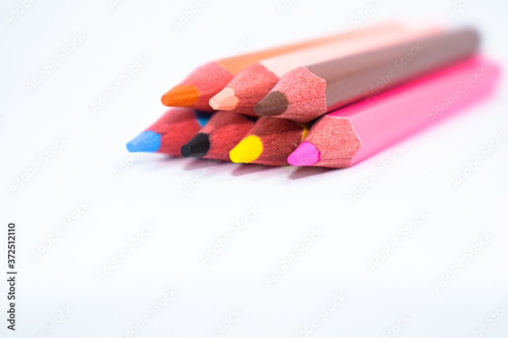 Seven different colored wood pencil crayon placed on a white background Seven different colored wood pencil crayon placed on a white background