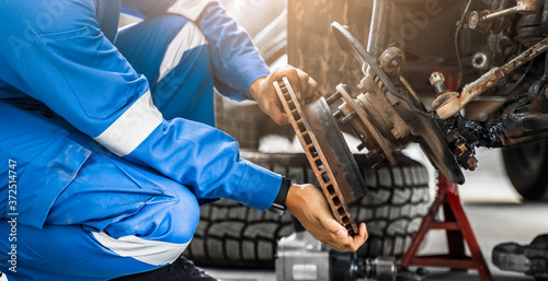 Fotografía Mechanic Asian man close up fixing repairing car rotor spindle hub automobile ve