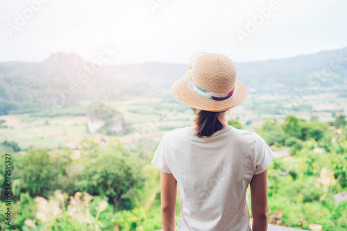 Asian attractive young woman traveler tourist hiking wearing hat back view standing silhouette looking at mountain nature landscape view scenery, hot summer wearing hat feeling peaceful joyful happy © Have a nice day 