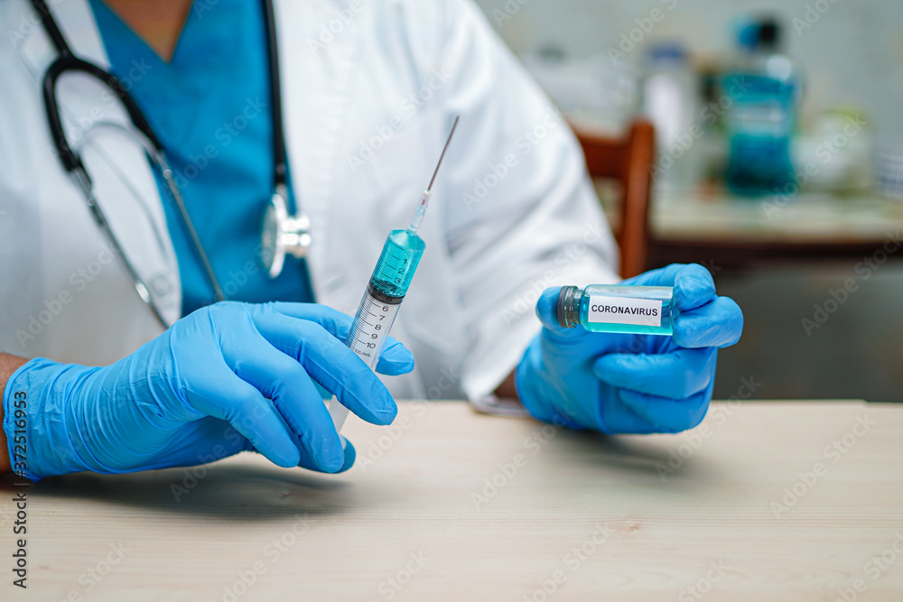 Doctor holding syringe with vaccine development medical for doctor use to treat illness patients Novel Coronavirus Covid-19 vaccine at hospital. Doctor holding syringe with vaccine development medical for doctor use to treat illness patients Novel Coronavirus Covid-19 vaccine at hospital.