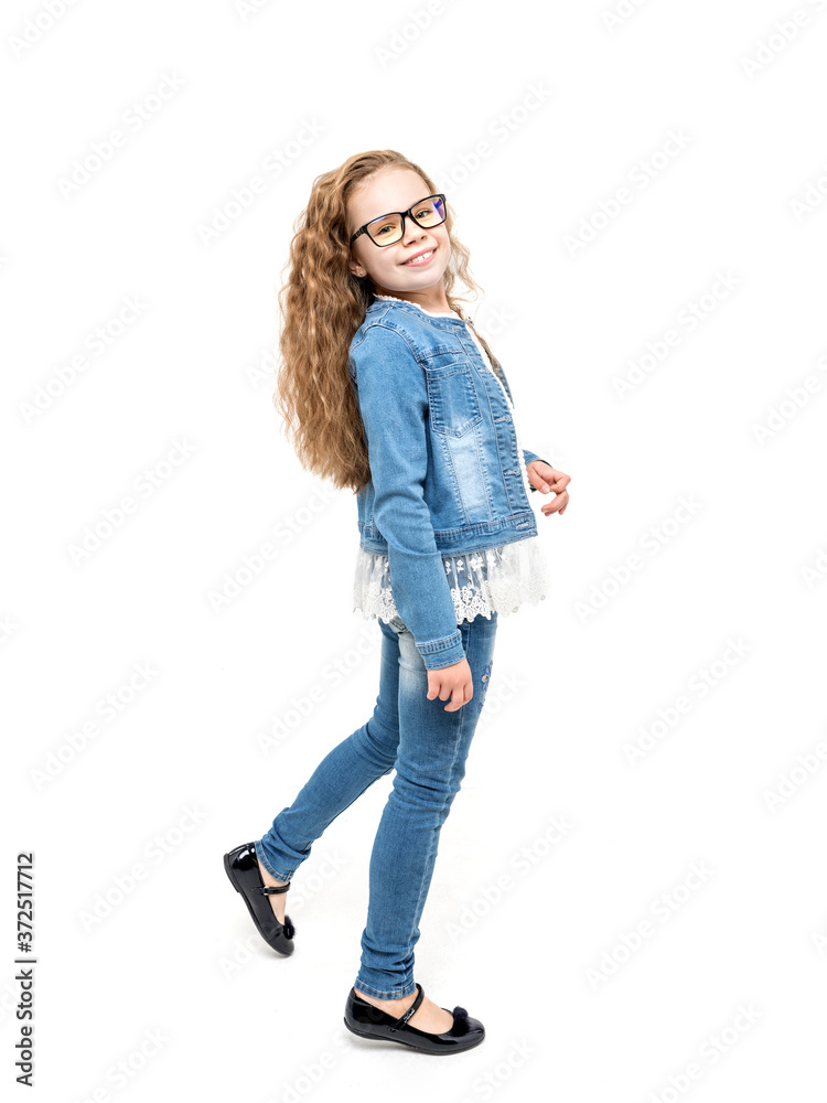 Cute little girl with wavy hair and in casual denim outfit against white background Cute little girl with wavy hair and in casual denim outfit against white background