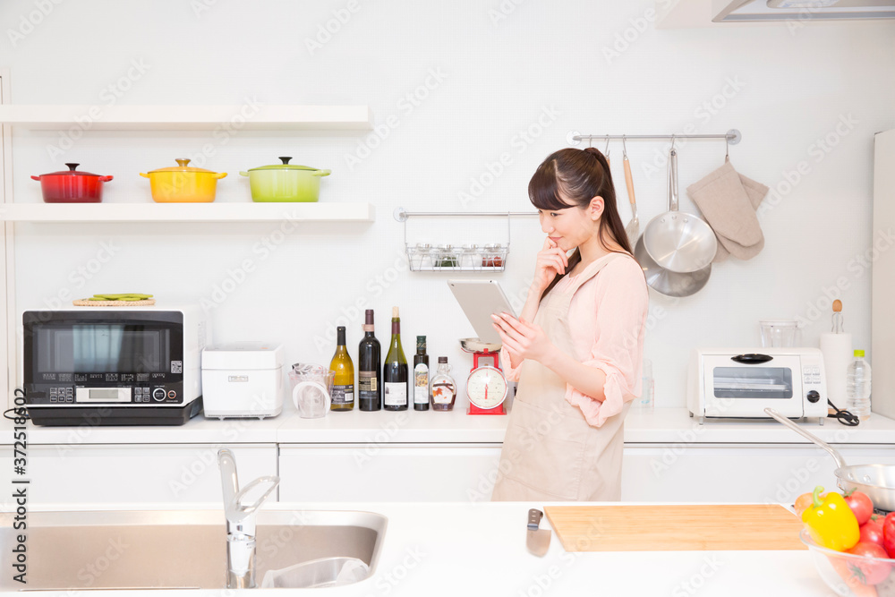 キッチンでタブレットPCを操作する女性