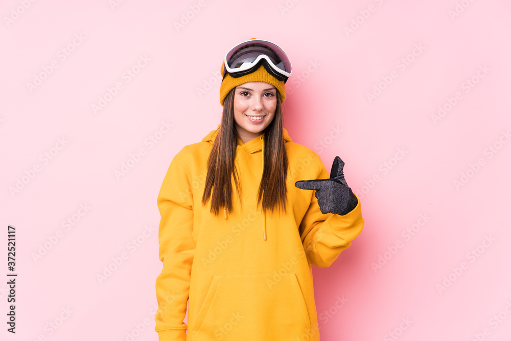 Young caucasian skier woman isolated person pointing by hand to a shirt copy space, proud and confident
