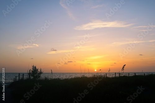Sunset in Captiva Sanibel Island  Florida. Gulf of Mexico at dusk. Sun sets over beach on Captiva Island over calm waters. Illuminated dreamy summer sunset.