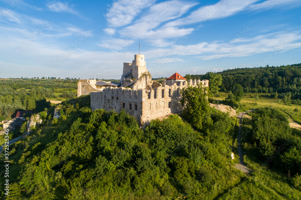 Rabsztyn, Poland. Ruins of medieval royal castle on the rock in Polish Jurassic Highland. Aerial view in sunrise light in summer