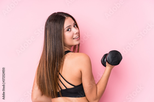 Young caucasian sporty woman holding a dumbbell