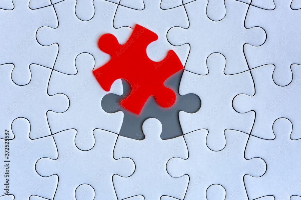White jigsaw puzzle pieces on gray background White jigsaw puzzle pieces on gray background