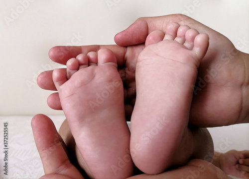 Baby feet in mother's hands. Mom and her Child. Happy family concept.