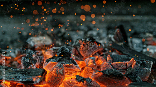 Barbecue Grill Pit With Glowing And Flaming Hot Charcoal Briquettes, Close-Up photo