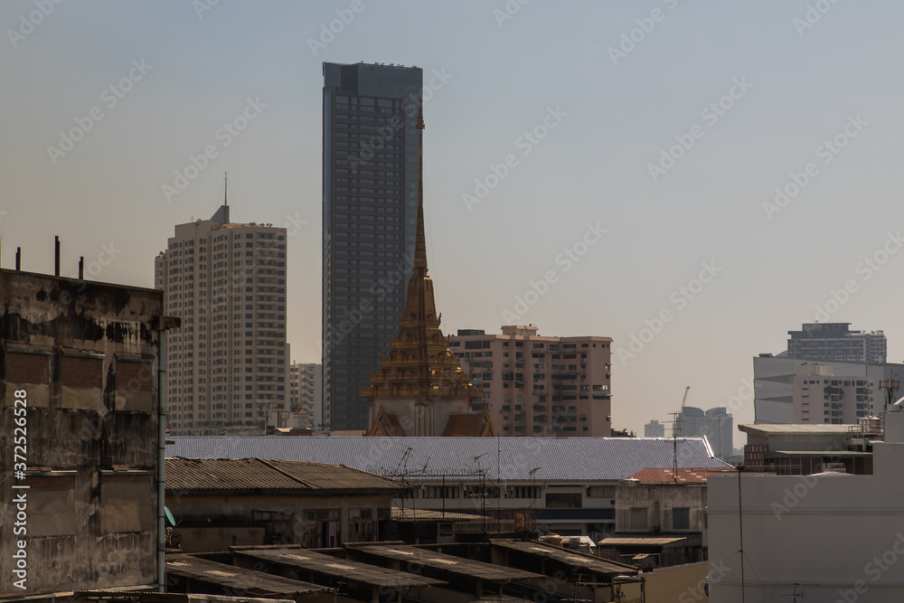 City view of Bangkok with Thai temple and modern tall buildings that perfectly coexist. No focus, specifically.
