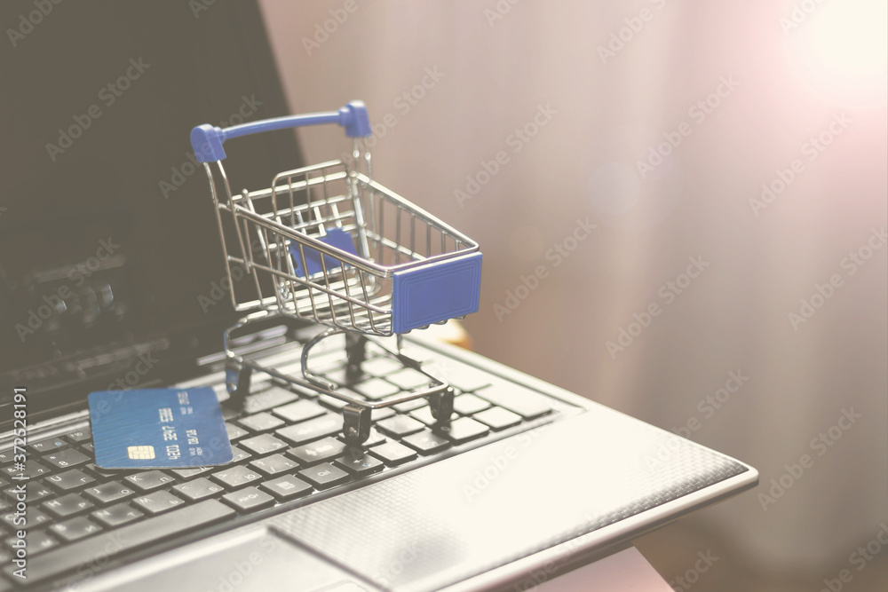 Online shopping with home delivery. Shopping basket on laptop keyboard. Online shopping with home delivery. Shopping basket on laptop keyboard.