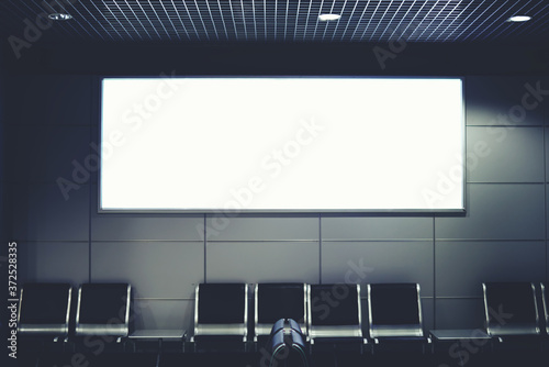 Blank billboard with clean space for publicity content or text message, advertising mock up in interior, public commercial board in waiting of airport hall with empty chairs, template banner indoors