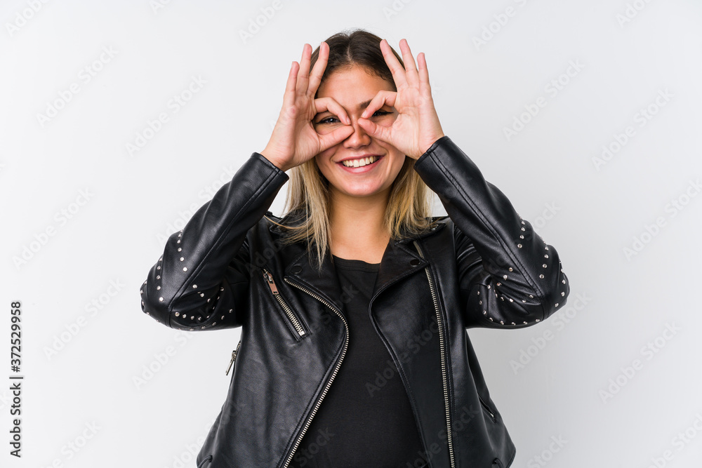 Young caucasian woman wearing a black leather jacket showing okay sign over eyes Young caucasian woman wearing a black leather jacket showing okay sign over eyes