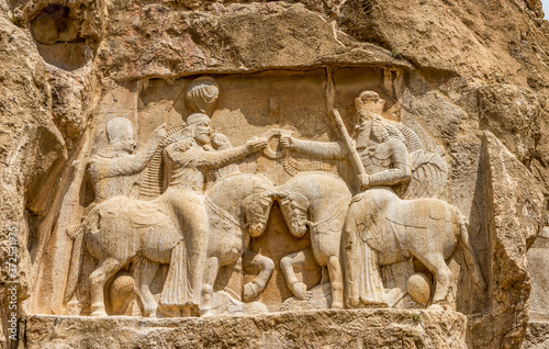 The necropolis of Naqshe-e-Rustam, near Persepolis in Iran, beside  the Tombs of King Darius and King Xerxes,  beautiful rock reliefs of the King Ardachir and Ahura Mazda photo