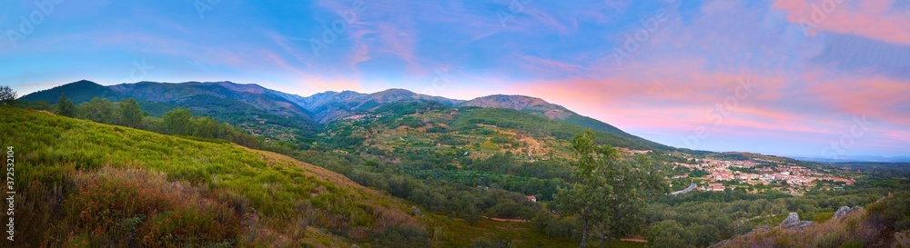 Large-format panoramic view of the Sierra de Gredos at sunset, with an aerial view of Jarandilla de la Vera. Extremadura. Spain