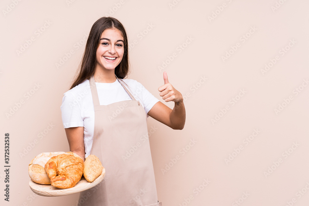 Young caucasian baker woman isolated smiling and raising thumb up Young caucasian baker woman isolated smiling and raising thumb up