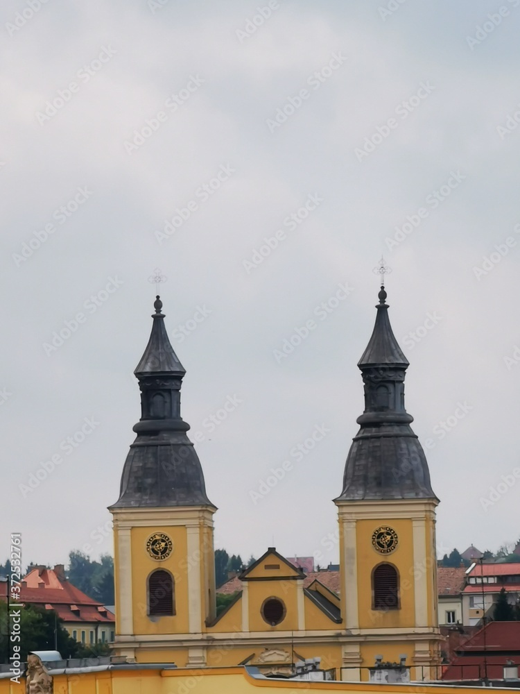 A clock tower in front of a building in Eger