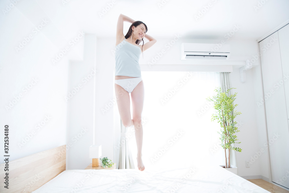 ベッドでジャンプする女性 ベッドでジャンプする女性