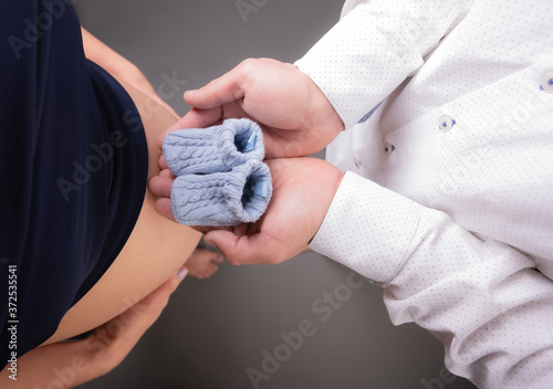 cute Closeup of heart shape of a couple hands together on the pregnant woman's belly. selective focus.