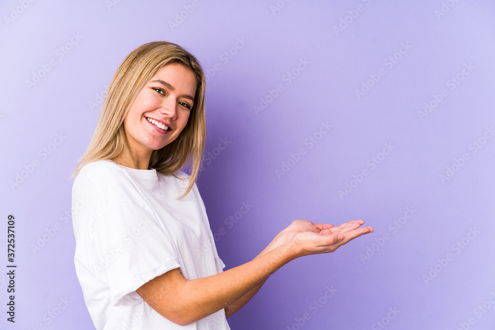 Young blonde caucasian woman isolated holding a copy space on a palm. Young blonde caucasian woman isolated holding a copy space on a palm.
